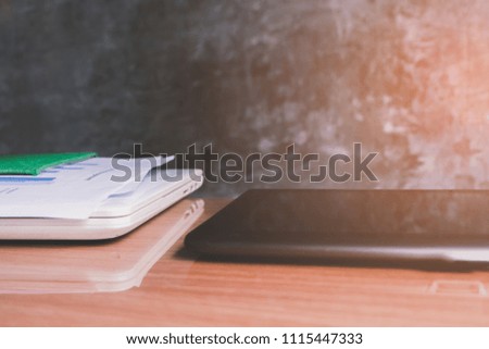 Notebook, Laptop and documents for business, on modern loft cement wall background.