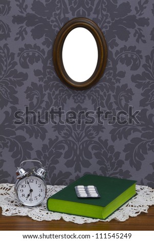 Alarm clock with green book on table cloth