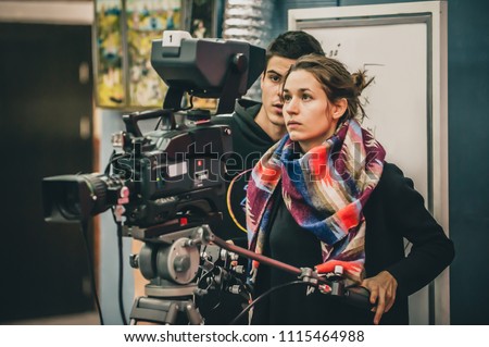 Behind the scene. Cameraman and assistant shooting the film scene with camera in film studio Royalty-Free Stock Photo #1115464988