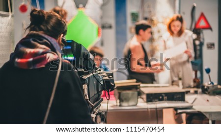 Behind the scene. Actor in front of the camera on the film set in film studio.  Royalty-Free Stock Photo #1115470454