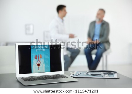 Laptop with picture of urogenital system and blurred people on background