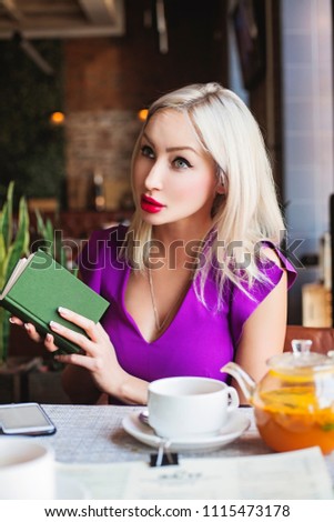 Pretty Woman with Book in Restaurant