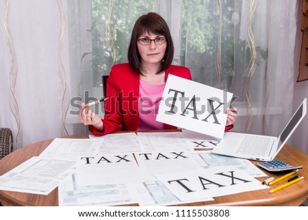 Woman showing word 'tax' on sheet of paper