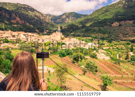 Girl takes a picture of  skyline Valldemossa in Mallorca. The most beautiful place to visit.