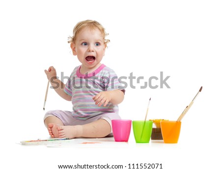 Funny kid with open mouth painting with brush