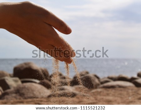 Photo of sand being poured from the hand
