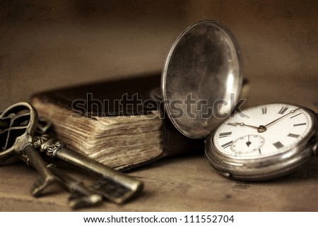 Vintage grunge still life with pocket watch, and old book and brass keys. Royalty-Free Stock Photo #111552704