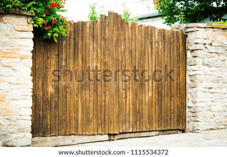 
old wooden gate in a stone fence