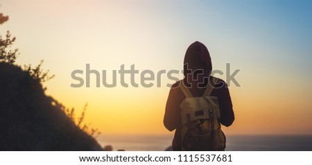 tourist traveler with backpack on morning relax time, hiker looking on sunset to valley in trip, hipster young girl enjoying peak of mountain background evening seascape ocean horizon, relax holiday