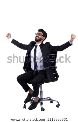 Young sitting man wear suit sitting on office chair spread his fisted up excitedly, isolated on a white background.