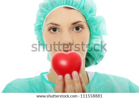 Female doctor holding red heart in hand.