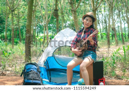 attractive hipster woman adventure at holiday travel happy and smile with playing ukulele on camping.