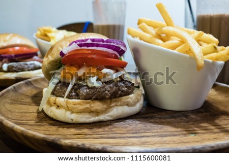Hamburger with fries on wooden tray