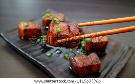 Braised pork belly oriental style food appetizer on dark background. Selective focus. Royalty-Free Stock Photo #1115603966