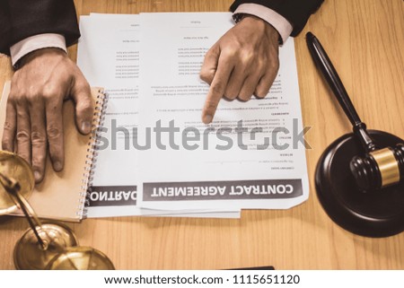 Hand businessman or lawyers sitting office Pointing contract papers on wood table. Law of advisor Concepts and vintage, Sunset light.Selective Focus