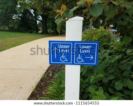 sidewalk with blue wheelchair entrance sign