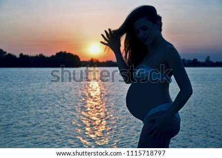 pregnant woman on sunset background
