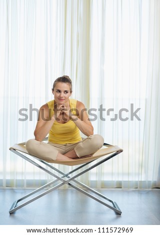 Thoughtful young woman sitting on modern chair