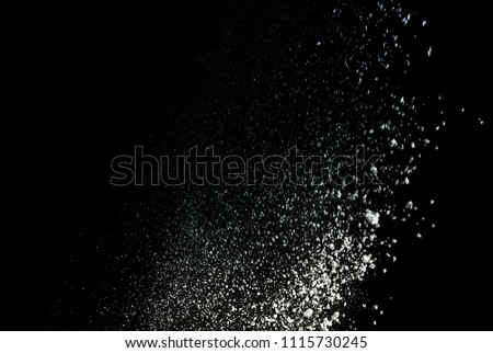 Freeze motion of white dust explosion on black background. Holi cloud
