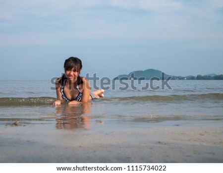 Asia teenage girls wearing bikini at the beach with copy space.
