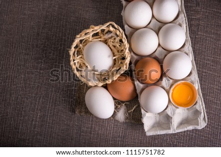 raw egg in a tray on a wooden table. rustic dairy background. top view