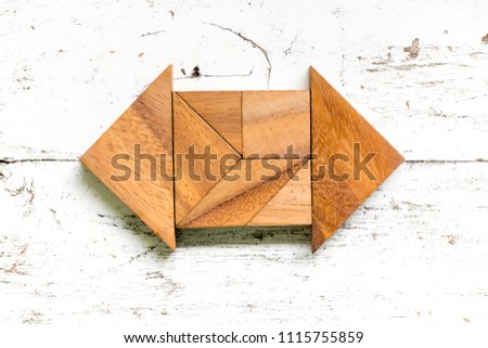 Tangram puzzle in 2 side arrow shape on old white wood background