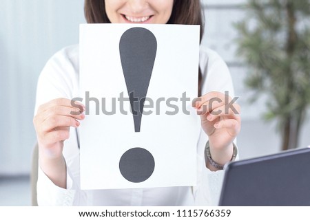 business woman showing an exclamation mark sitting at the Desk