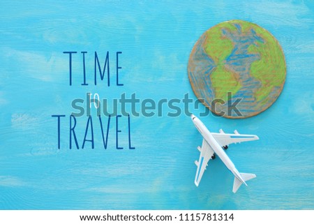 top view image of airplane and earth globe over blue wooden background