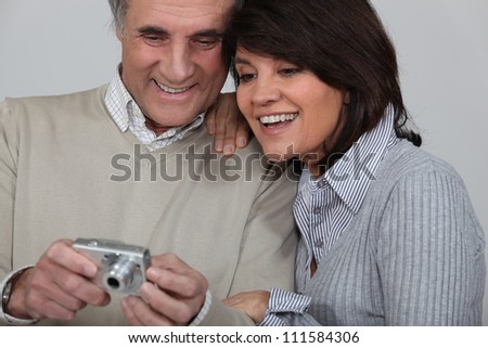 Married couple looking at photographs taken on digital camera