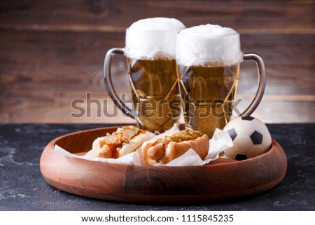 Photo of two glasses of beer, hot dogs, soccer ball