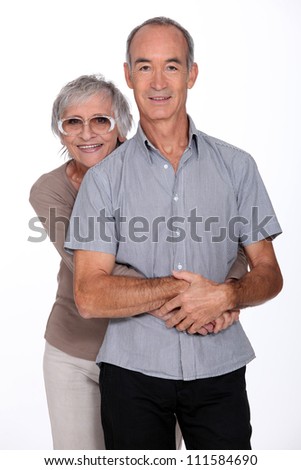 Affectionate senior couple stood in the studio