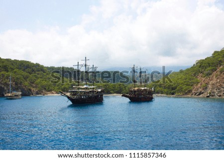 Wooden yacht in the calm blue Mediterranean Sea in the green lagoon with mountains