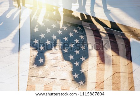 Shadows of People in a street and Flag of The USA as Background concept toned Picture 