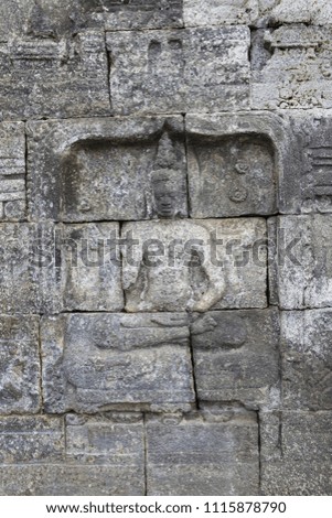 Beautiful bas-relief wall decor with Buddha carved in stone at Borobudur Temple, Yogyakarta, Indonesia