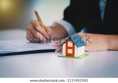 Businesswoman signing the document contract  of a sale for a new house. Real estate services for buying your home. Loan for the purchase of housing.home loan and insurance concept. Royalty-Free Stock Photo #1115901905