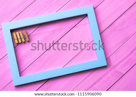 Blue frame with clamps  isolated on violet wooden background, with path