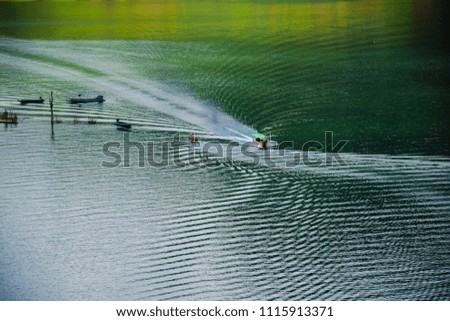 The boats are sailing in the river at Khun Dan Prakan Chon Dam, The longest mashed-compress concrete dam in Thailand and in the world, Nakhon Nayok, Thailand