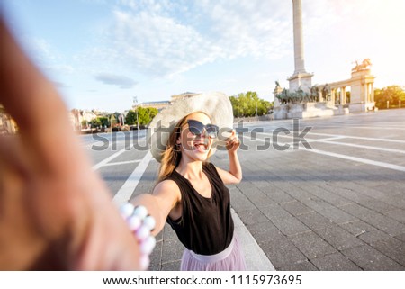 Young woman tourist making selfie photo on the Heroes square traveling in Budapest city, Hungary