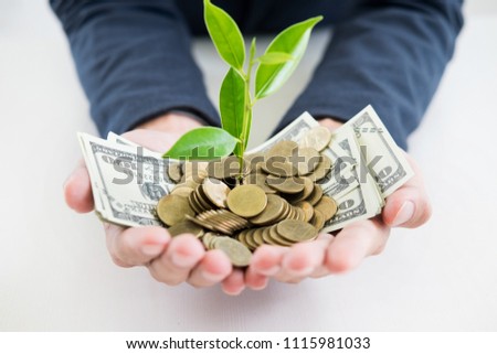 Business man hand make palm up with growing up money coins and sprout of plant savings financial concept success.