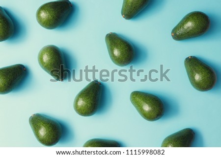 Avocado colorful pattern on a pastel blue background. Summer concept. Flat lay.