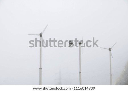 Wind turbines installed on the mountain with mist after rain.