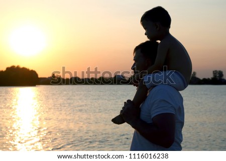Father and son watching the sunset
