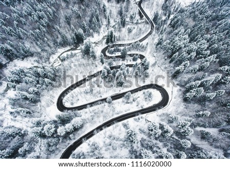 Snowy road in the forest. Extreme winding road high up in the mountains
