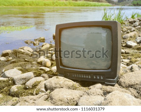 old TV on the river bank