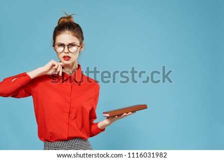  serious business woman with glasses with a notebook on a blue background                              
