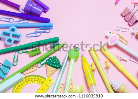 Colorful pink background with various School accessories are laid out in the form of a rainbow. Line, raw. Frame with empty space in center. Flat lay top view. Study arrangement