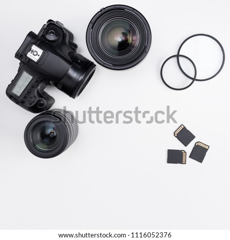 modern dslr camera, lenses, photo equipment and copy space over white table background