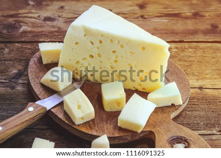 cheese and knife on a wooden board