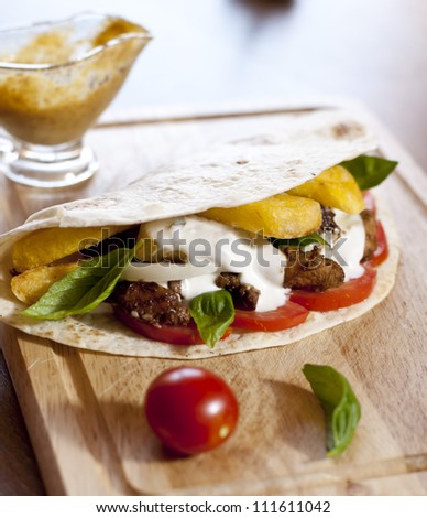 tortilla with chicken meat, fries and basil