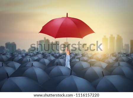 businessman with red umbrella among others, unique different concept Royalty-Free Stock Photo #1116157220